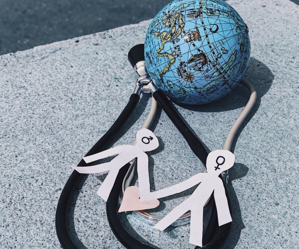 Tres elementos (estetoscopio, globo terráqueo y dos personas de género masculino y femenino) enlazados entre sí para representar una sanidad universal e igualitaria para todas las personas. Según la Organización Mundial de la Salud, en los países en desarrollo unos 2.000 millones de personas carecen de acceso a medicamentos esenciales.  Manuela Areán Rosabianca, 5 de abril de 2018, Gijón, Asturias.